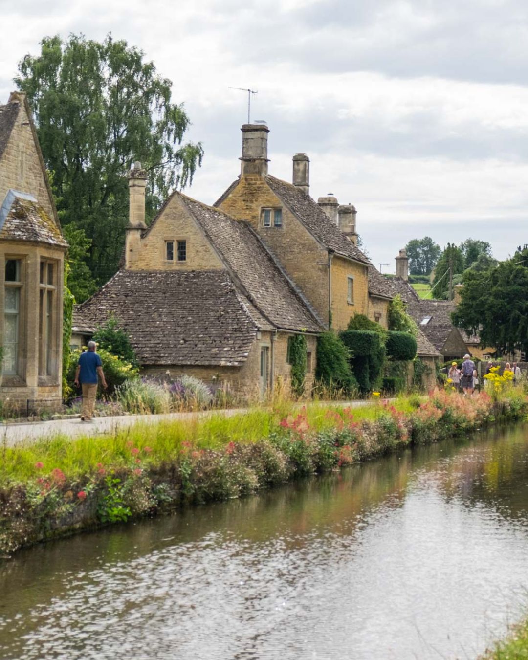 cotswolds-inglaterra-pueblo-rural Pueblo de Cotswolds en Inglaterra con casas de piedra junto al río