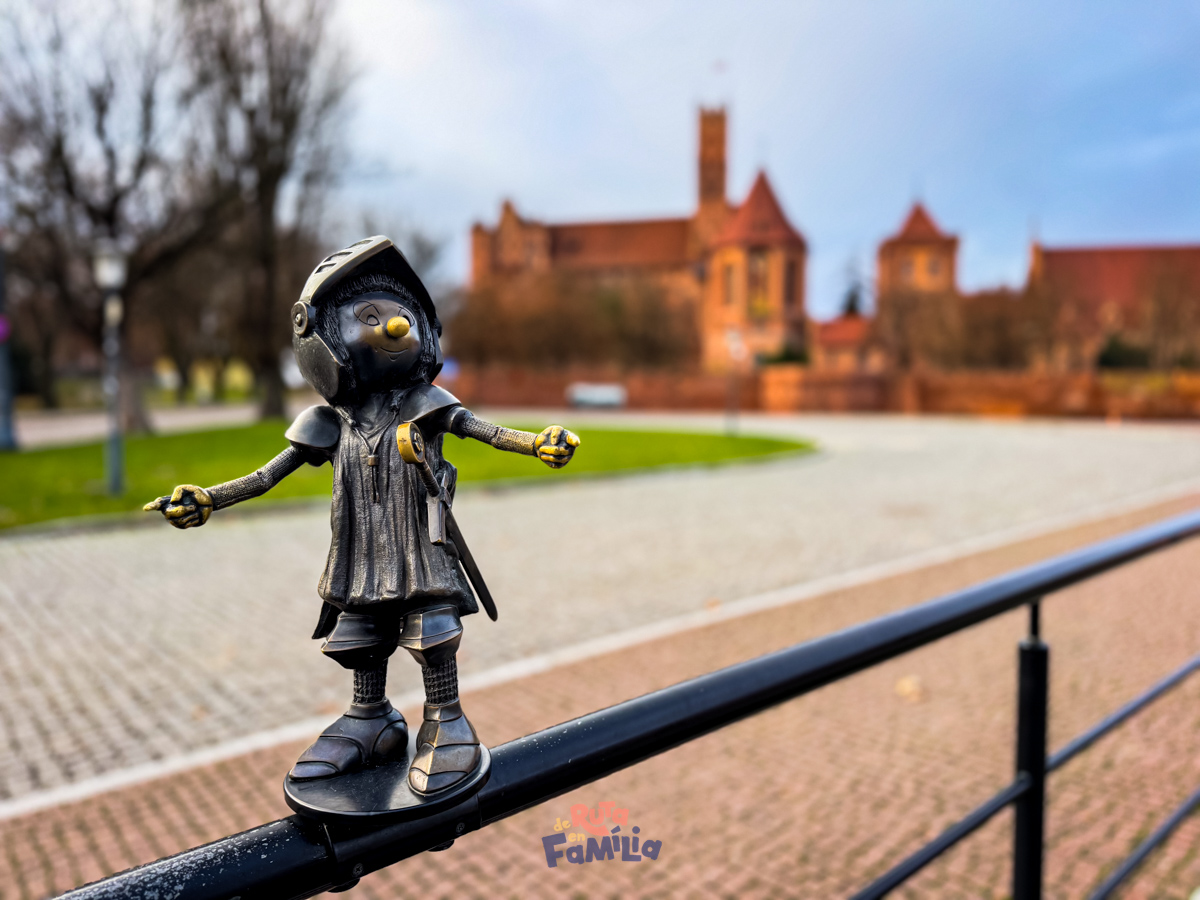 Petita figura d'un cavaller amb el castell de Malbork al fons