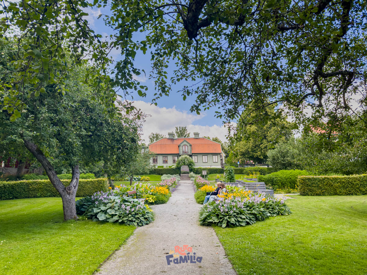 jardin_en_sigtuna_derutaenfamilia Jardín cuidado en Sigtuna con sendero central, flores y una casa al fondo