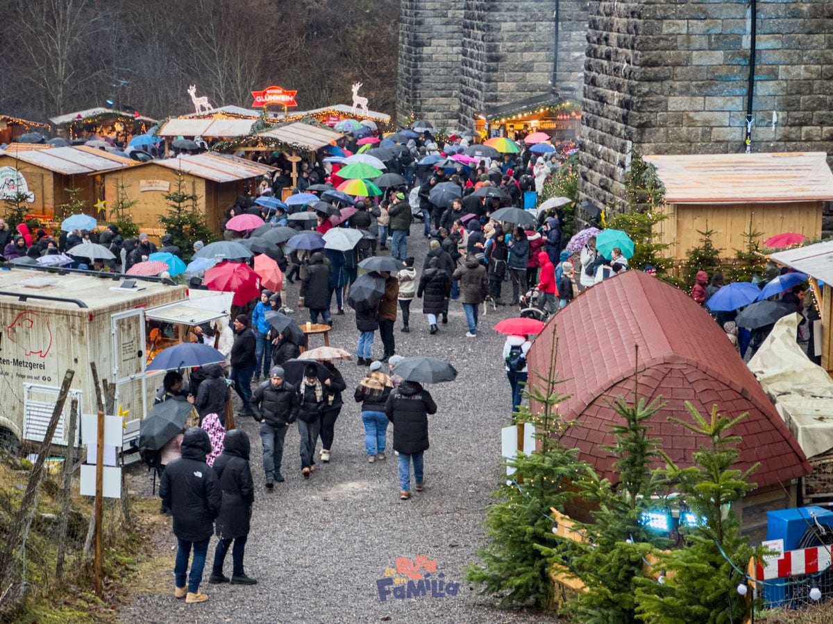 Puestos y visitantes en el mercado de Navidad de Ravennaschlucht bajo la lluvia
