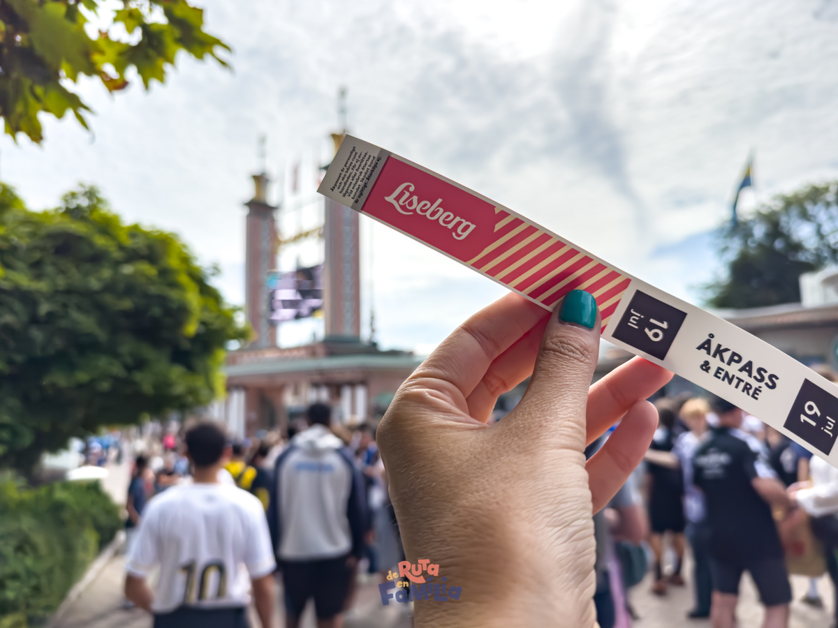 pulsera_de_acceso_liseberg_derutaenfamilia Pulsera de acceso a Liseberg sostenida frente a la entrada del parque