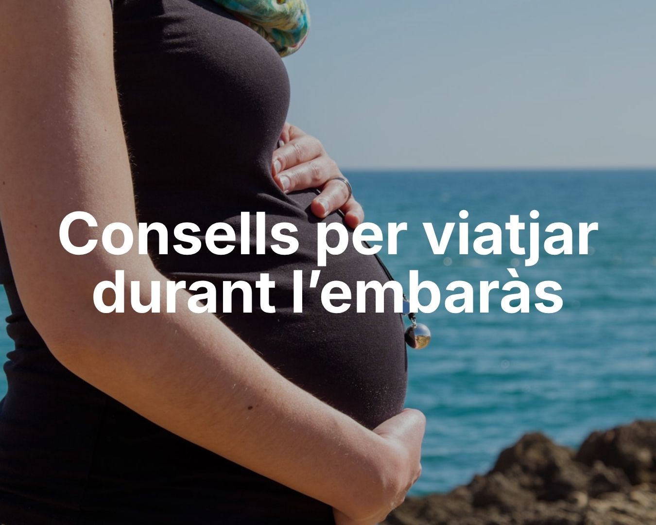 Dona embarassada davant del mar durant un viatge relaxant